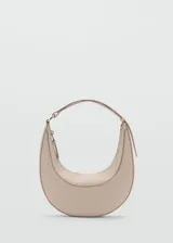 Bolso de hombro tipo media luna color beige, con cierre superior de cremallera y asa corta.
