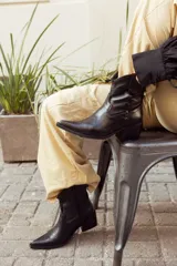 Bota texana corta negra de cuero, con taco de 5cm y detalles bordados en el empeine.