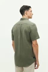 Camisa de manga corta confeccionada en una mezcla de lino y algodón, con cuello clásico, cierre frontal de botones y bolsillo en el pecho con logo bordado.