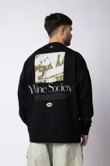 Buzo de cuello redondo y corte oversize, confeccionado en frisa suave. Presenta un diseño minimalista en color negro con un pequeño logo ovalado en el centro del pecho y una estampa sutil en el lateral inferior derecho.