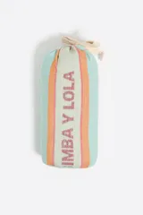 Toalla de playa de algodón, color rosa pálido, con diseño de rayas verticales en tonos beige, naranja y rosa. Presenta franjas verticales con el logo "BIMBA Y LOLA" repetido.
