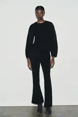 Pantalón de tiro alto con corte ancho y recto, confeccionado en tejido de punto elástico y flexible con cintura elástica.