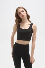 Top deportivo de bretel ancho, color negro, con cuello redondo profundo y diseño ajustado al cuerpo.