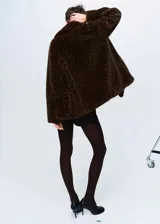 Abrigo de efecto pelo con diseño de estampado de leopardo, cuello camisero, corte oversize y cierre frontal con botones.