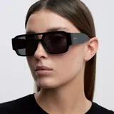 Lentes de sol con diseño oversized de estilo aviador con doble puente y frontal flat-top. Montura negra con lentes polarizadas oscuras.