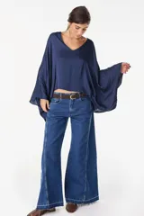 Blusa de algodón azul marino con escote en V, mangas murciélago amplias y diseño corto de corte asimétrico.