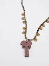Collar corto con cuentas de piedras naturales facetadas en tonos multicolor, dijes metálicos dorados en forma de pequeñas monedas y un dije central en forma de palmera hecho de piedra rosada.