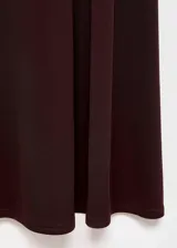 Vestido midi de corte evasé en color marrón oscuro, confeccionado en tejido elástico. Presenta cuello asimétrico, manga larga y diseño sin cierre.