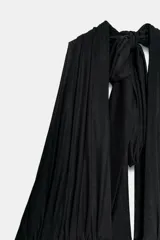 Top negro de cuello halter con escote en pico pronunciado. Presenta un cuerpo estructurado y una parte superior de tul plisado con detalle de lazada tipo foulard en el cuello. Incluye cierre lateral con cremallera oculta.