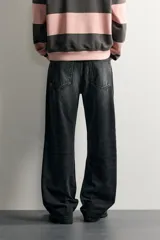 Jeans de denim de algodón en color azul con efecto desgastado, tiro medio y corte recto de ajuste holgado (loose fit). Cuenta con diseño clásico de cinco bolsillos y cierre frontal con cremallera y botón.