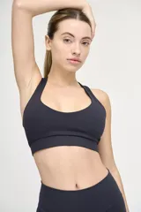 Top deportivo negro con escote redondeado, espalda cruzada y cintura con doble tela.