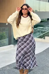 Falda midi evasé con estampado a cuadros en tonos violeta, marrón y blanco, con corte fluido y cierre lateral.