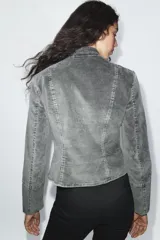 Chaqueta entallada de terciopelo color gris con efecto acid wash, cuello subido, manga larga y cierre frontal con ganchos metálicos. Presenta detalles de pasamanería con falsos botones en el delantero de inspiración militar.