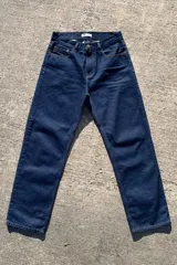 Pantalón de jean azul oscuro con corte baggy y calce relajado. Presenta cinco bolsillos clásicos y costuras reforzadas en tono contrastante.