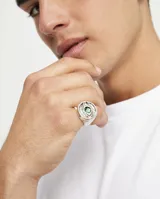 Anillo tipo sello plateado con forma de ojo y cristal facetado verde.