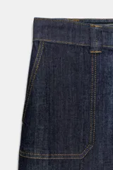 Pantalón de jean tiro medio con corte culotte, pernera ancha y corta. Presenta bolsillos delanteros de plastrón, costuras decorativas verticales y cierre frontal con cremallera y botón.