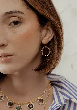 Aros dorados tipo argolla con dije circular de resina negra rodeado de strass.