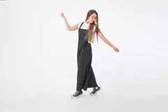 Mono negro de denim con corte oversize, breteles anchos y piernas anchas.