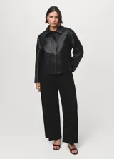 Jeans de tiro alto con diseño wide leg, cierre frontal de cremallera y botón, trabillas para cinturón y dos bolsillos de parche en la parte delantera.