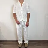 Camisa de tejido calado color blanco, con cuello tipo cubano, manga corta y cierre frontal con botones.