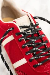 Zapatillas rojas de gamuza con detalles en cuero blanco y suela de goma color caramelo.