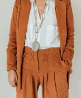 Collar plateado con cadena de eslabones grandes y dije de escudo con diseño intrincado.