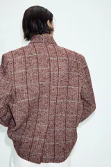 Blazer de lana con diseño de cuadros, cuello subido, manga larga, bolsillos delanteros y cierre frontal cruzado con un botón.
