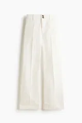 Pantalón de tiro alto confeccionado en lona de algodón de corte recto, con raya marcada al frente y en la espalda, y cierre frontal con dos botones.