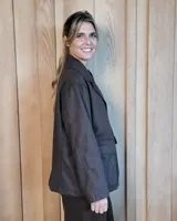 Sobrecamisa de paño color beige, con cuello solapa, cierre frontal de botones y dos bolsillos delanteros con solapa.