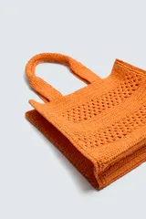 Bolso tipo shopper de diseño trenzado en color tostado, con estructura rectangular, dos asas de mano y compartimento principal abierto.