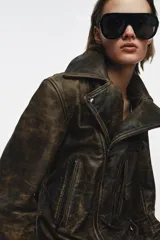Chaqueta tipo biker de cuero con efecto desgastado, cuello de solapa, cierre frontal con cremallera metálica, bolsillos delanteros con cremallera y bolsillo pequeño con solapa, mangas largas con cremalleras en los puños y bajo con trabillas.