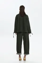 Chaqueta de algodón de calce relajado, color verde oscuro, con broches frontales, bolsillos aplicados y detalles regulables con cordones en las mangas.