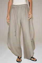 Pantalón ZARA Woman Collection de lino 100%, de tiro medio y color gris claro, con cintura elástica ajustable mediante cordones y bajo redondeado con aberturas laterales.