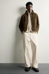 Pantalón relaxed fit negro confeccionado en tejido de algodón con estructura diagonal, estilo de cinco bolsillos y cierre frontal con cremallera y botón metálico.