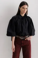 Camisa marrón con cuello clásico, abotonada al frente y mangas 3/4 abullonadas.