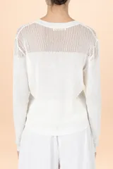 Blusa de tejido de punto color blanco, con cuello redondo, mangas largas y detalle de textura acanalada en la parte superior y en los puños.