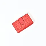 Billetera roja con diseño acolchado en forma de rombos y cierre con broche a presión.