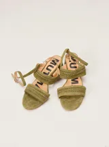 Sandalias de gamuza verde militar con taco bajo, tiras anchas con bordado artesanal en tiento de cuero y correa fina ajustable al tobillo.