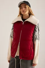 Chaleco puffer rojo con cuello de sherpa color crema, cierre frontal con cremallera y bolsillos laterales.