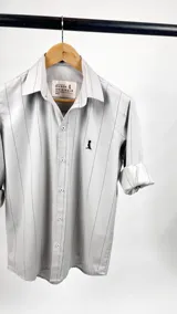 Camisa de vestir de algodón color gris claro con finas rayas verticales negras, cuello italiano, manga larga con puños abotonados y logo bordado en el pecho. Marca Duxon Originals.