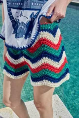 Short tejido a crochet con diseño de rayas en zigzag en colores blanco, azul, verde y rojo.