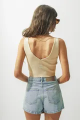 Top de punto acanalado color beige, con escote en V y corte cropped.