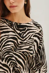 Sweater de punto con diseño de estampado animal print de cebra, cuello redondo y mangas largas con corte holgado.