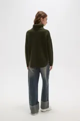 Polera de tejido de punto con cuello alto, diseño holgado y mangas largas. Presenta una textura de relieve tipo waffle en color natural.