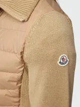 Cárdigan híbrido Moncler con frente acolchado tipo puffer y mangas y espalda de tejido de punto. Presenta cuello alto, cierre frontal con cremallera y parche con logo en la manga.