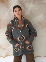 Saco tejido a mano de color negro, con diseño geométrico multicolor, cuello smoking y cierre frontal con dos botones.