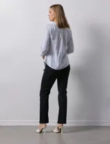 Blusa de lino estampada a rayas verticales en tonos blanco, verde, violeta, amarillo y rosa. Cuello a la base con escote en V y abertura central con botones. Delantera con bolsillos de parche. Mangas largas regulables con presilla y botón.