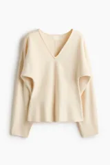 Remera de punto fino suave color beige, con escote en V, cintura entallada y mangas dolman largas.