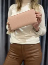 Billetera de cuero sintético color rosa con cierre dorado.