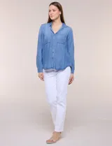 Camisa confeccionada en tela tencel azul, de estilo casual y silueta semi holgada. Presenta cuello camisero tradicional, abotonadura frontal completa, dos bolsillos superiores en el pecho y mangas largas con presilla y botón para arremangar.